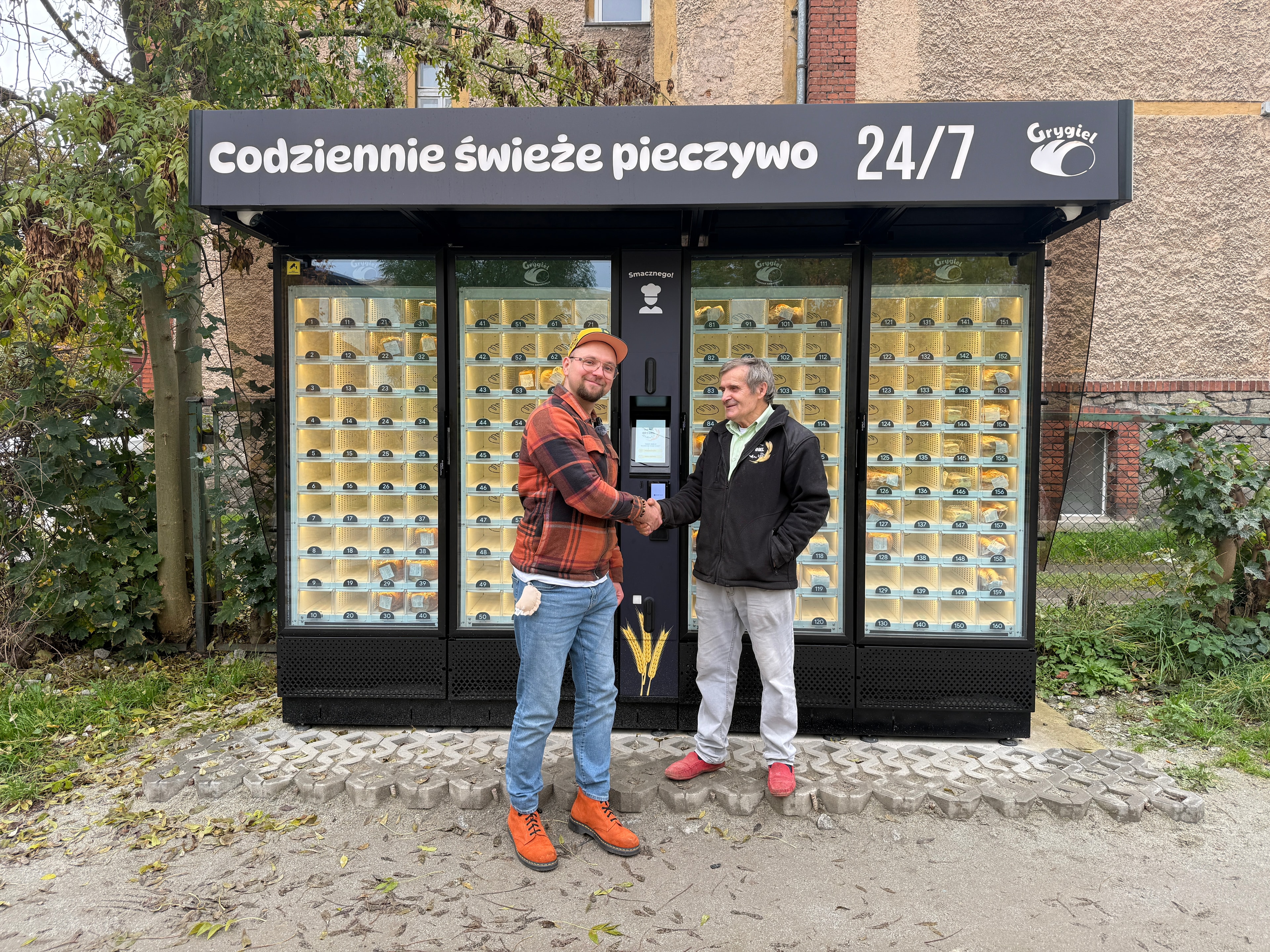 Distributeur de boulangerie Grygiel avec deux personnes devant l’appareil