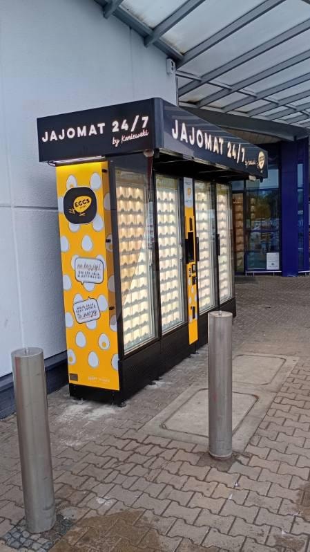 Vue latérale d’un distributeur jaune d’œufs près d’une boutique